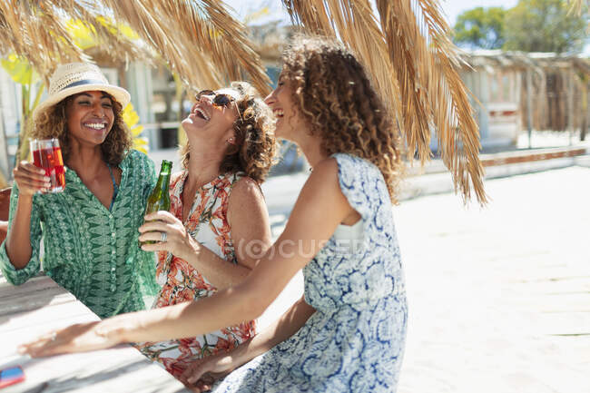 Щасливі жінки друзі п'ють в сонячному барі — стокове фото
