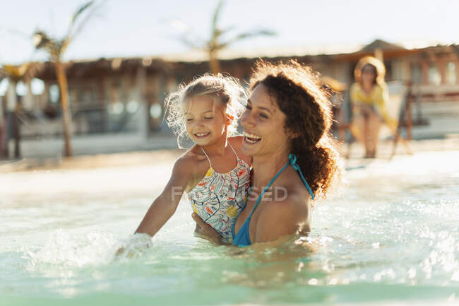 Mãe e filha felizes nadando no oceano ensolarado — Fotografia de Stock