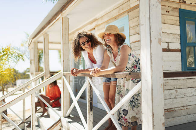 Mother and adult daughter relaxing on sunny beach hut patio — Stock Photo