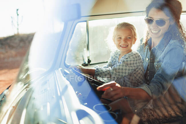 Счастливая мать и дочь за рулем фургона — стоковое фото