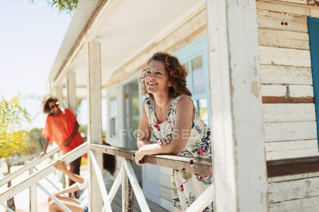 Mulher feliz relaxante na praia ensolarada cabana pátio — Fotografia de Stock