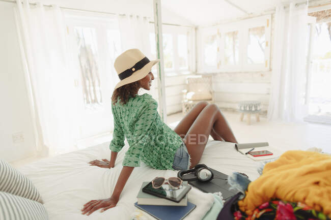 Mujer relajante en cama cabaña de playa - foto de stock