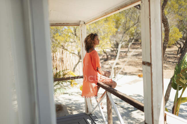 Serena giovane donna rilassante sul patio della capanna sulla spiaggia — Foto stock