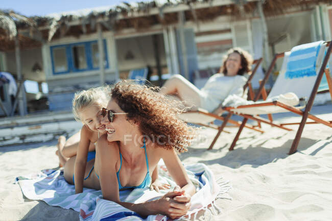 Feliz madre e hija en la playa soleada - foto de stock