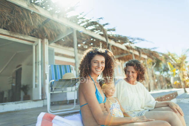 Porträt glückliche Mehrgenerationenfrauen, die es sich vor einer sonnigen Strandhütte gemütlich machen — Stockfoto
