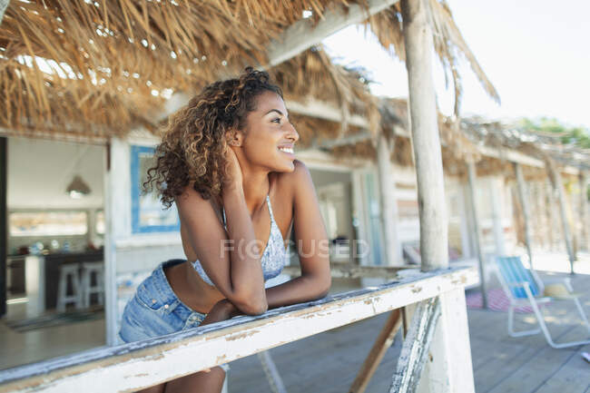 Glückliche, unbeschwerte junge Frau entspannt auf der Strandhüttenterrasse — Stockfoto