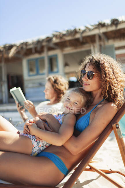 Ritratto felice figlia rilassante con madre sulla spiaggia soleggiata — Foto stock