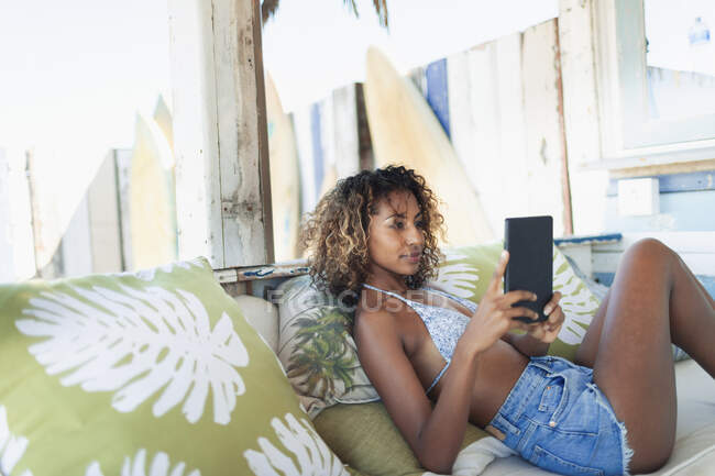 Young woman using digital tablet on beach patio — Stock Photo