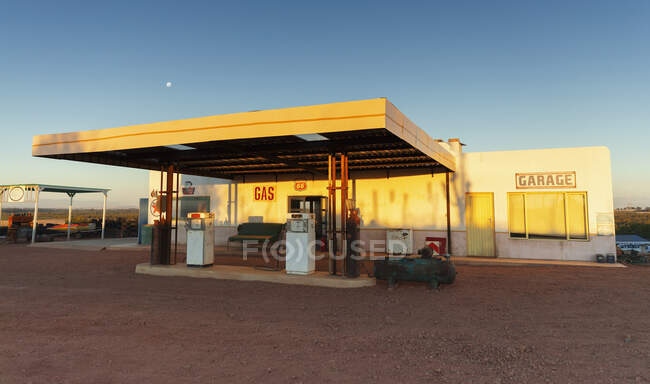 Station essence abandonnée et garage au coucher du soleil — Photo de stock