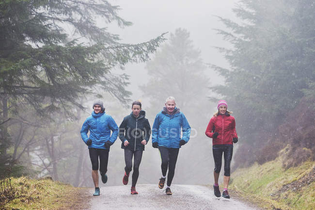 Family jogging in woods — Stock Photo