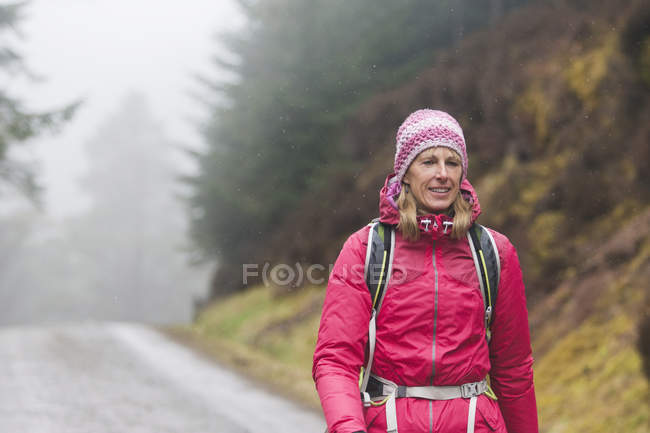 Woman hiking in rain — Stock Photo