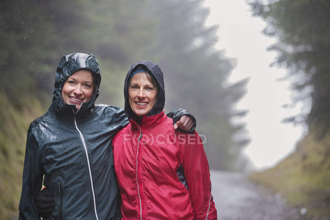 Portrait of mother and daughter hiking in rain — Stock Photo