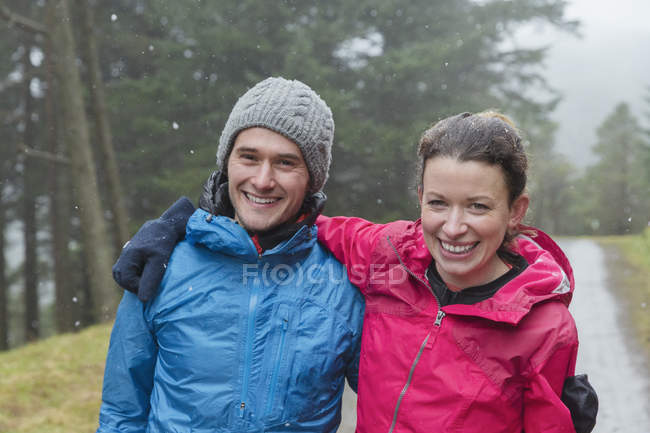 Happy couple hiking in rain — Stock Photo