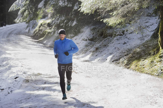Homme jogging dans la neige — Photo de stock