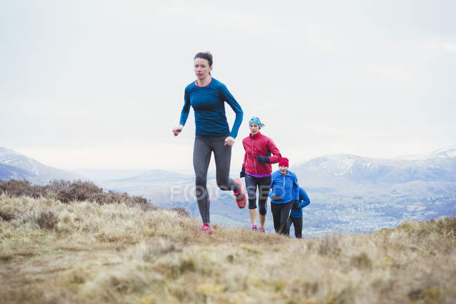 Friends jogging up mountain — Stock Photo