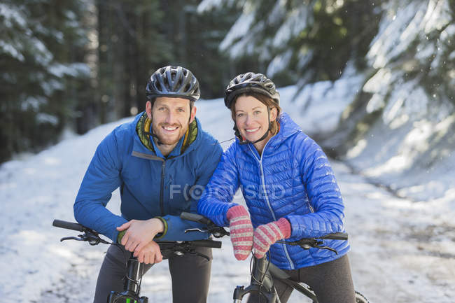 Coppia felice mountain bike sulla neve — Foto stock
