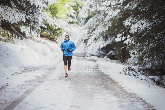 Homem correndo em bosques nevados — Fotografia de Stock