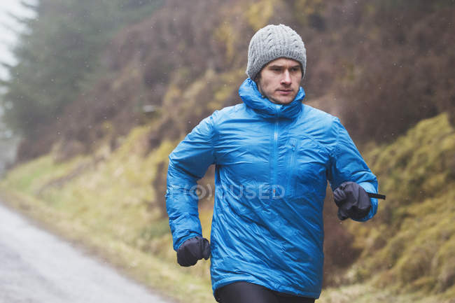 Hombre corriendo bajo la lluvia - foto de stock