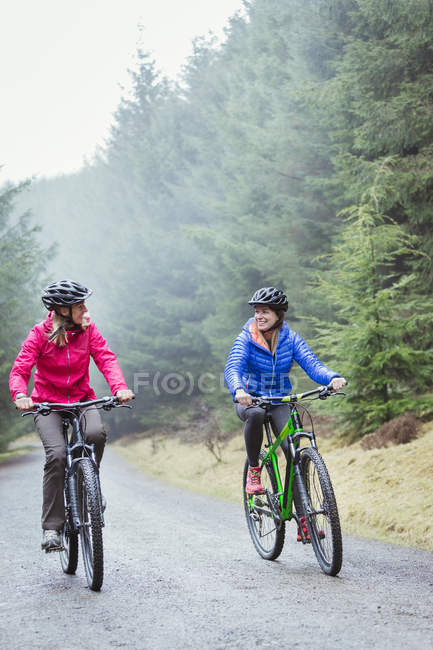 Bicicleta de montaña mujer en bosque - foto de stock