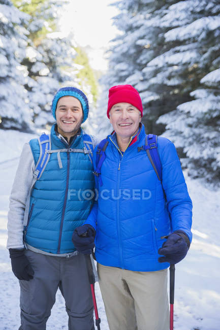 Portrait of father and son hiking in snow — Stock Photo