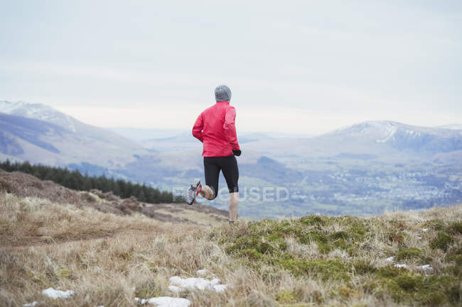 Вид сзади человека, бегущего по горной тропе — стоковое фото