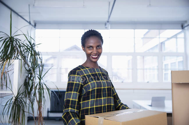 Portrait of confident businesswoman moving into new office — Stock Photo