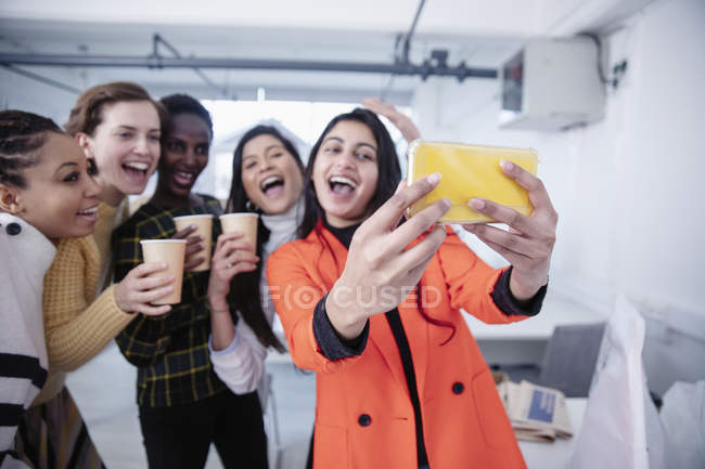 Happy businesswomen celebrating, taking selfie in office — Stock Photo