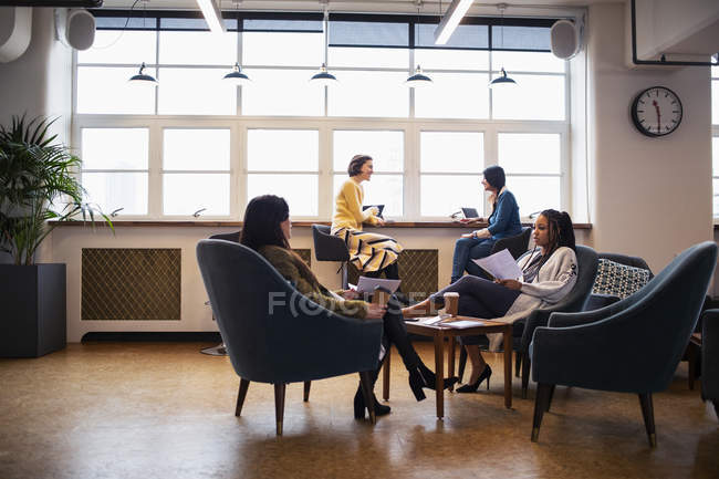 Предпринимательницы разговаривают в офисе открытого плана — стоковое фото