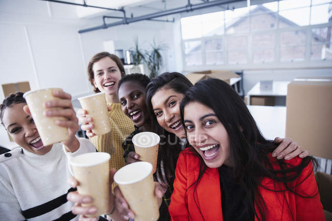 Portrait happy businesswomen celebrating new office — Stock Photo