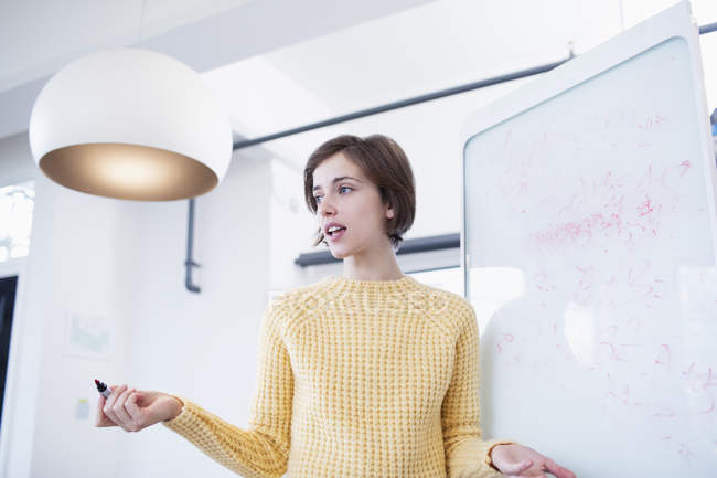 Businesswoman at whiteboard leading meeting — Stock Photo
