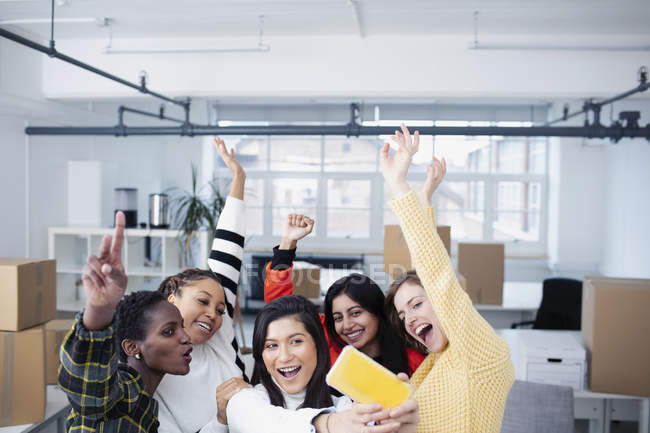 Щасливі ділові жінки святкують новий офіс, приймаючи селфі — стокове фото