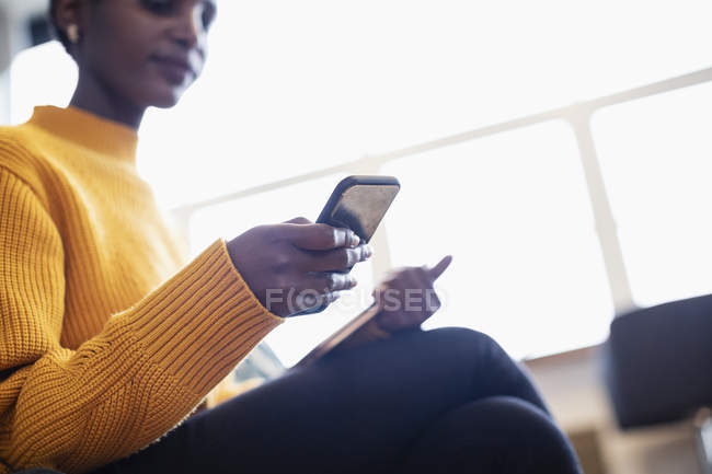 Деловая женщина с помощью смартфона в офисе — стоковое фото