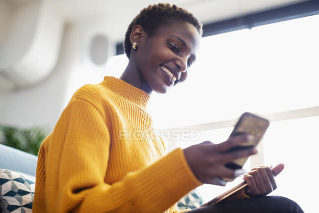 Mujer de negocios sonriente usando teléfono inteligente - foto de stock