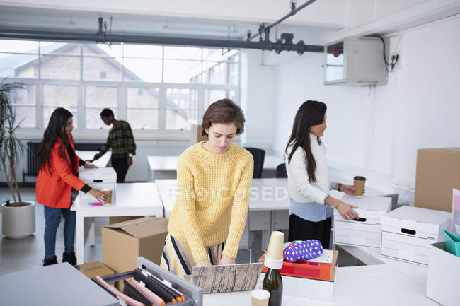 Бізнес-леді розпаковуються і працюють в новому офісі — стокове фото