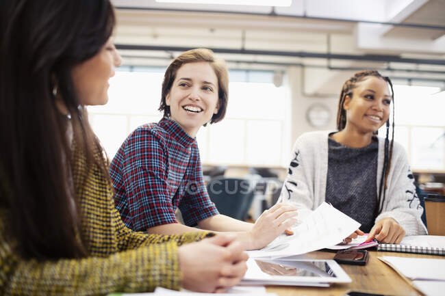 Mujeres de negocios sonrientes hablando en la reunión - foto de stock