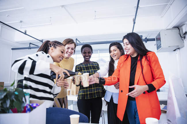 Businesswomen celebrating new office, pouring champagne — Stock Photo