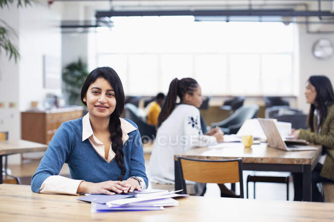 Portrait femme d'affaires confiante travaillant dans un bureau ouvert — Photo de stock