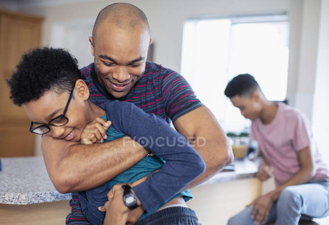 Playful father and son in kitchen — Stock Photo