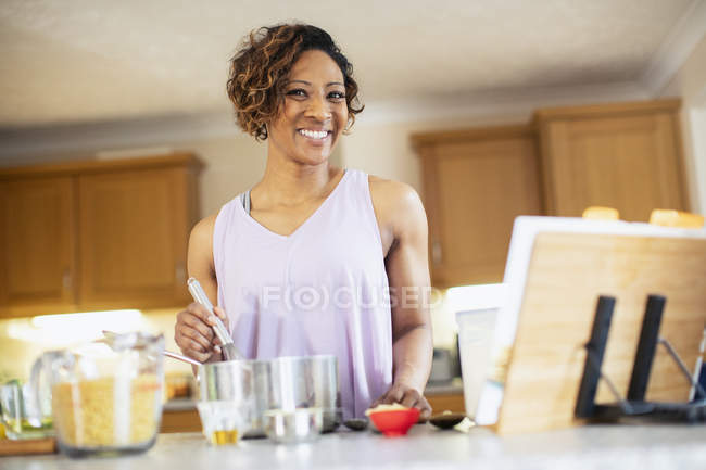 Портрет усміхненої, впевненої жінки, що готує на кухні — стокове фото