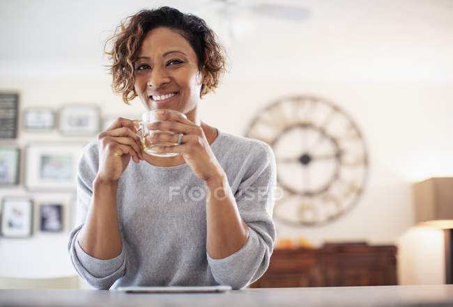 Porträt einer lächelnden, selbstbewussten Frau, die Tee trinkt — Stockfoto