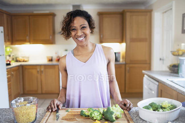 Portrait de femme souriante et confiante cuisinant dans la cuisine — Photo de stock