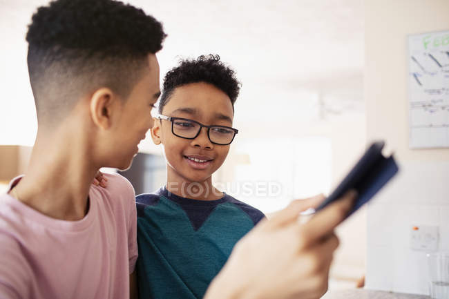 Irmãos usando tablet digital em casa — Fotografia de Stock