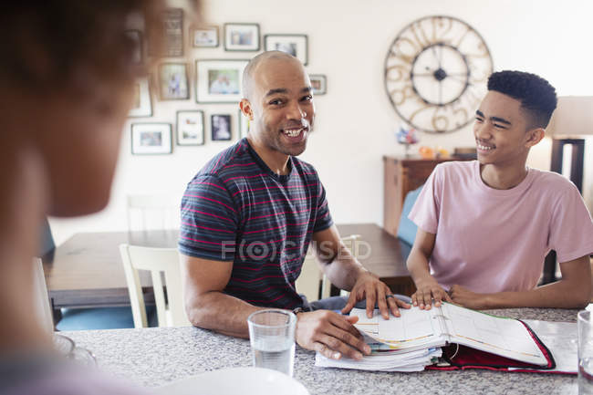 Father helping son with homework in kitchen — Stock Photo