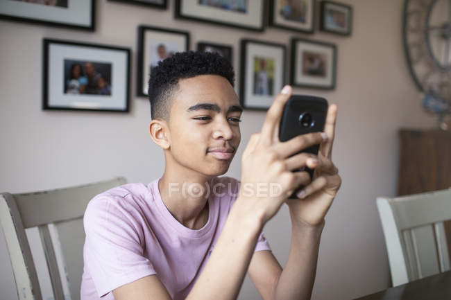 Teenager nutzt Smartphone zu Hause — Stockfoto