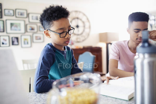 Boy studying and reading book at home — Stock Photo