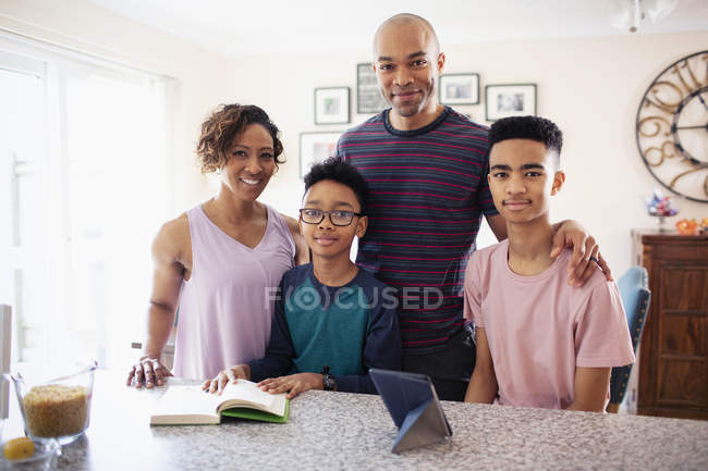 Retrato de familia sonriente en la cocina - foto de stock
