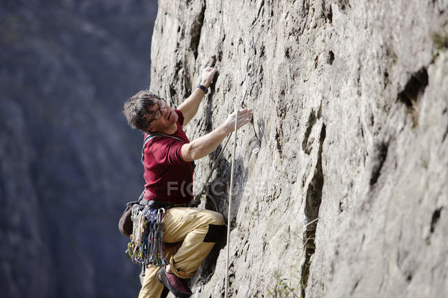 Masculino escalador de rocha escalar rosto de rocha — Fotografia de Stock