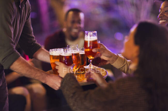 Man serving beer glasses to friends at party — Stock Photo
