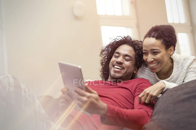 Щаслива пара використовує цифровий планшет на дивані — стокове фото
