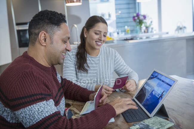 Glückliches Paar mit Reisepass plant Urlaub am digitalen Tablet — Stockfoto